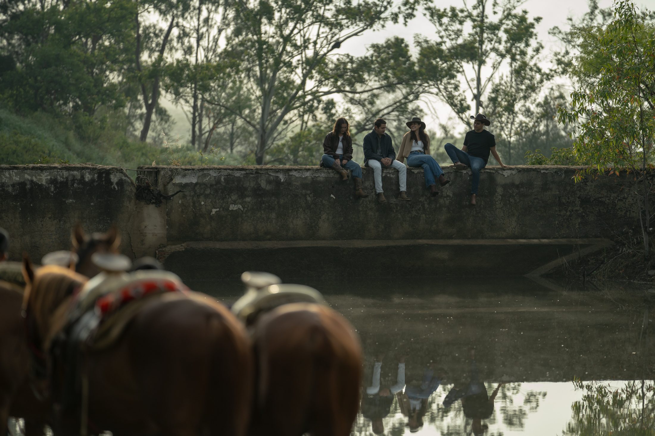 Grupo de amigos junto al agua con caballos en primer plano, Reserva Caxcanes